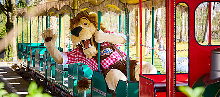 Franz-Xaver in Schieneneisenbahn winkend wie er sich herauslehnt 